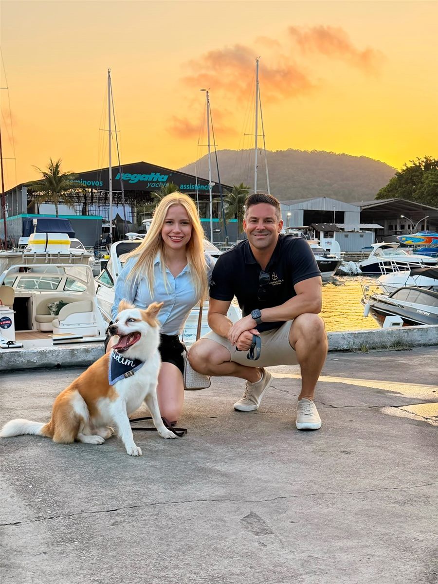 Alê Silveira com a noiva e o Pudim, seu cachorro, numa marina ao pôr do sol